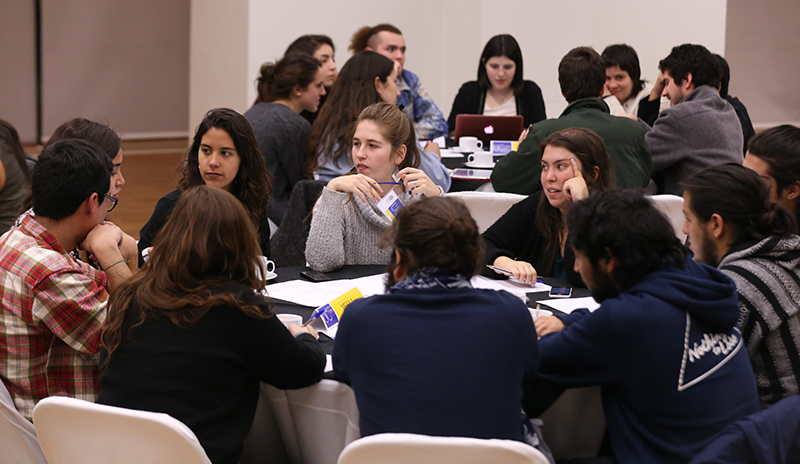 Personas dialogando en una mesa del UC Dialoga